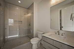 Full bathroom with vanity, a stall shower, and recessed lighting