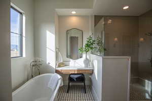 Full bathroom featuring walk in shower, vanity, a freestanding tub, tile patterned flooring, and recessed lighting
