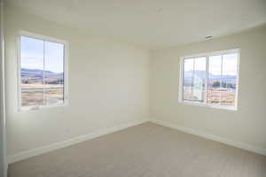 Carpeted empty room with a mountain view and recessed lighting