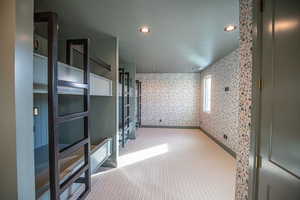 Carpeted spare room featuring a textured ceiling, wallpapered walls, and recessed lighting