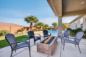 Fenced backyard with a fire pit and a patio