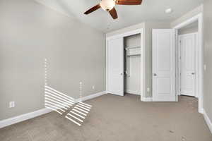 Unfurnished bedroom featuring carpet flooring, a ceiling fan, and a closet