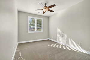 Empty room featuring carpet floors, ceiling fan, and a textured ceiling