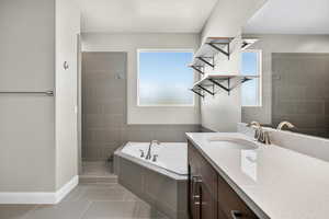 Full bath featuring a bath, vanity, light tile patterned floors, and a stall shower
