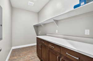 Laundry room with hookup for a washing machine, cabinet space, and wood tiled floors