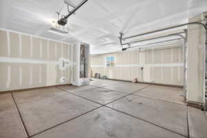 Garage featuring a garage door opener and water heater