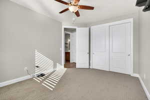 Unfurnished bedroom with carpet flooring, a ceiling fan, and a closet