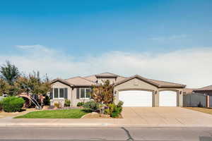 View of front facade featuring stucco siding, driveway, a garage, and a tiled roof
