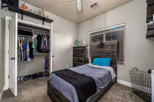 Carpeted bedroom featuring a closet and ceiling fan