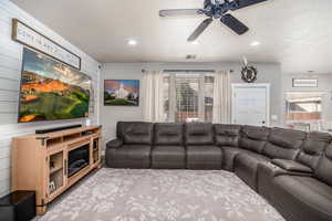 Living area featuring a ceiling fan, recessed lighting, and carpet