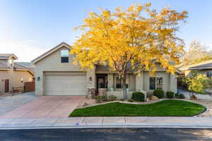 View of front facade featuring stucco siding, a garage, and concrete driveway