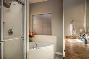 Full bath with a garden tub, vanity, and a stall shower