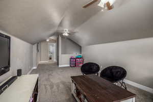 Office featuring light carpet, a ceiling fan, a textured ceiling, and lofted ceiling