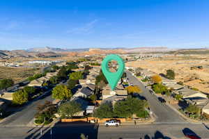 Aerial view of property and surrounding area with a mountain backdrop and nearby suburban area