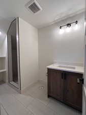Full bathroom featuring vanity, a textured ceiling, and light tile patterned flooring