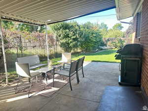 Fenced backyard with a patio area, an outdoor hangout area, and a grill
