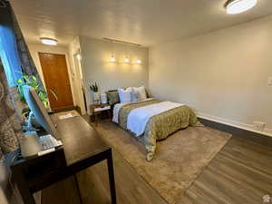 Bedroom featuring dark wood-type flooring and baseboards