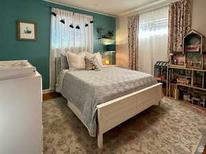 Bedroom featuring ornamental molding and wood finished floors