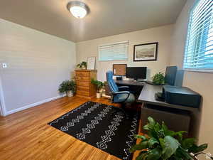 Office area with light wood finished floors and healthy amount of natural light