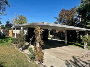 View of vehicle parking with driveway and an attached carport