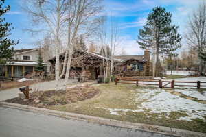 View of front facade with a chimney and driveway