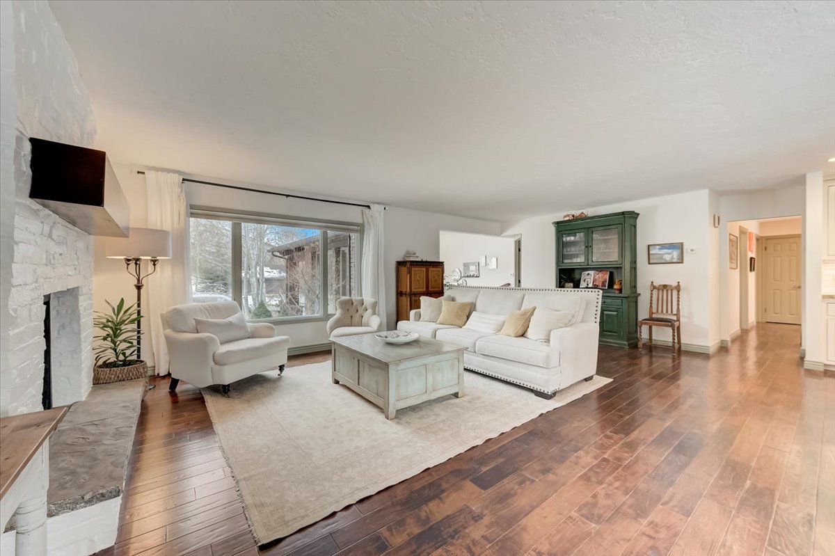 Living room with wood-type flooring, a fireplace, and a textured ceiling