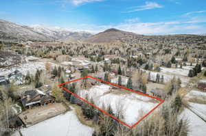 Snowy aerial view with property boundaries highlighted and a mountain view