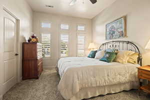 Carpeted bedroom with ceiling fan and baseboards