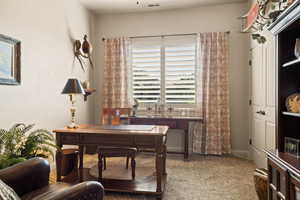 Home office with carpet floors and baseboards