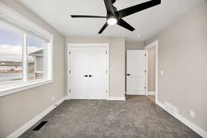 Unfurnished bedroom with carpet flooring, a closet, and a ceiling fan
