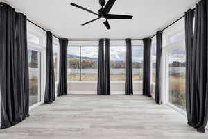 Spare room featuring a ceiling fan, light wood-type flooring, and a mountain view