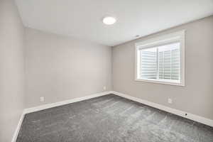 Carpeted empty bedroom with baseboards
