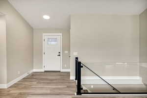 Entrance foyer with light wood-style floors and recessed lighting