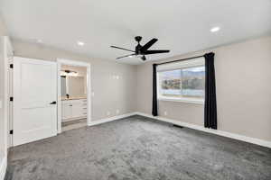 Unfurnished bedroom with light carpet, a ceiling fan, recessed lighting, and connected bathroom