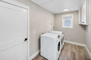 Laundry room with light wood-style floors and independent washer and dryer