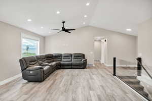 Living area with lofted ceiling, light wood-style flooring, recessed lighting, and a ceiling fan