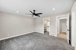 Unfurnished bedroom with recessed lighting, light colored carpet, a walk in closet, and ceiling fan