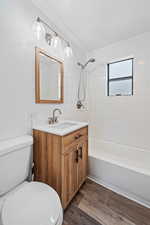 Bathroom with vanity, dark wood-style floors, and  shower combination