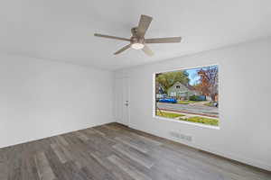 Empty room featuring a textured ceiling, wood finished floors, and a ceiling fan