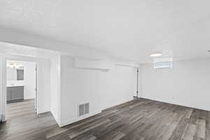 Below grade area featuring a textured ceiling and light wood finished floors