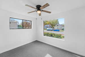 Unfurnished room with carpet floors, a ceiling fan, and a residential view