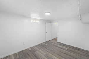 Finished basement with a textured ceiling and wood finished floors