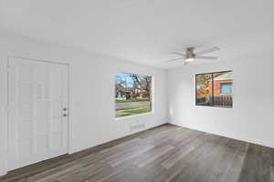 Empty room featuring a textured ceiling, wood finished floors, and a ceiling fan