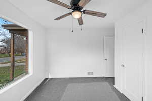 Spare room featuring carpet and a ceiling fan