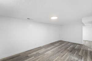 Unfurnished room with light wood-style flooring and a textured ceiling