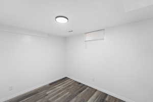 Finished below grade area with dark wood finished floors and baseboards