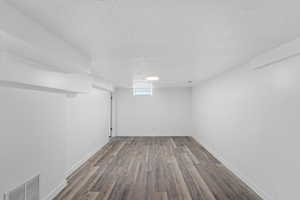 Below grade area featuring a textured ceiling and wood finished floors