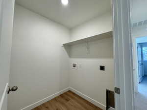 Laundry room with light wood-style flooring, hookup for an electric dryer, and washer hookup