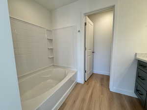 Bathroom with vanity, light wood-style floors, and bathing tub / shower combination