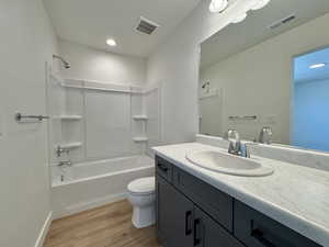 Bathroom featuring bathtub / shower combination, vanity, and light wood finished floors